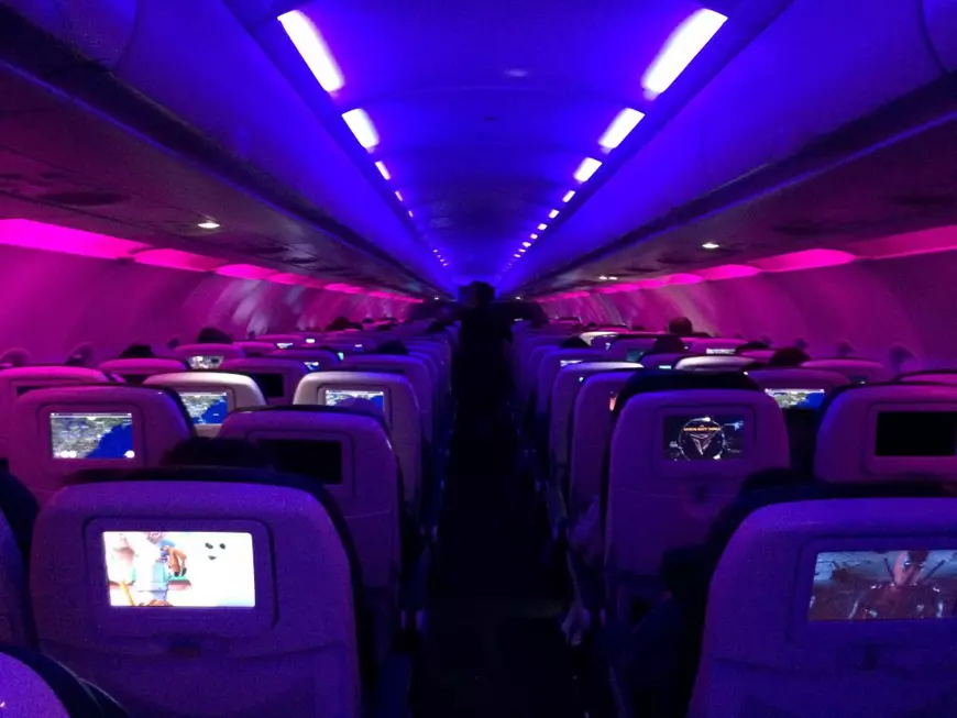 De ce parasolarul avioanelor trebuie ridicat şi de ce se stinge lumina la decolare şi la aterizare - Imagine cu interiorul unui avion de pasageri, în care sunt aprinse doar luminile de siguranţă.