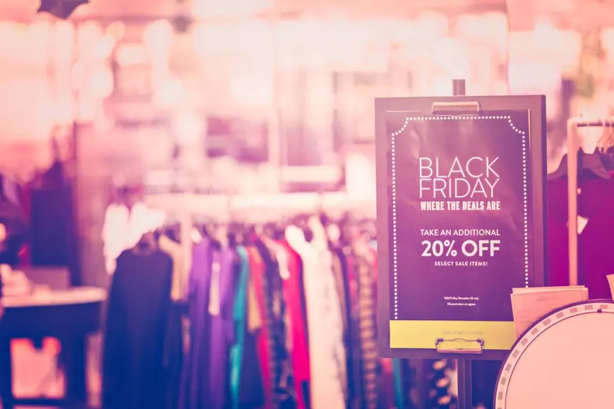 Care este momentul potrivit al anului să cumperi diferite lucruri - Imagine cu un afiş care anunţă reduceri de Black Friday într-un magazin.