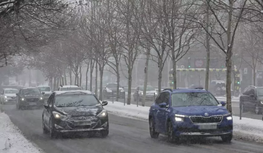 masini aflate in mers pe un bulevard din bucuresti. drumul este acoperit cu zapada