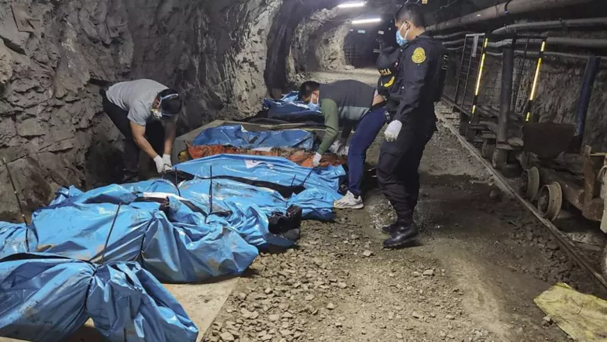 O fotografie publicată de Poliția din La Libertad pe 4 mai 2025 prezintă ofițeri de poliție lângă cadavrele a 13 muncitori găsiți morți într-o mină de aur din Pataz, nord-vestul Peru, in imagine se vad mai multe cadavre în saci de culoare așbastră, cu 4 polițisti care stau în picioare în interorul minei