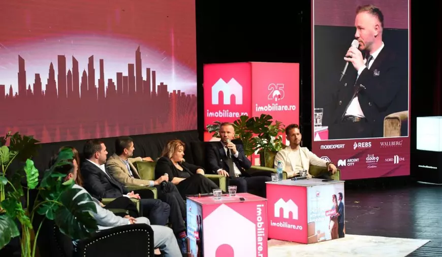 Dezvoltatori imobiliari invitați la Imobiliare.ro HUB Național 2025, în timp ce stau pe scaune, cu un logo Imobiliare.ro de culoare roșie pe fundal