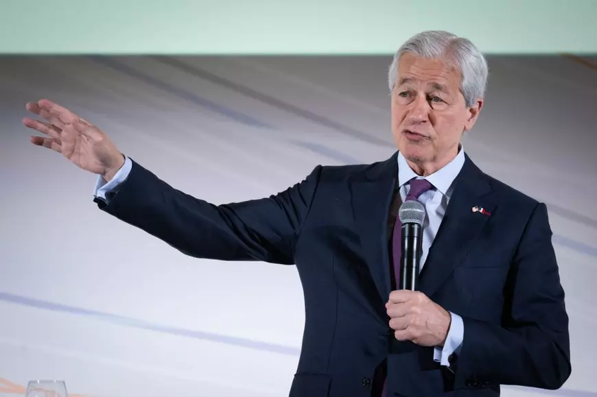 Jamie Dimon, CEO-ul JPMorgan, la costum negru, camasa alba si cravata tine un discurs de la microfon