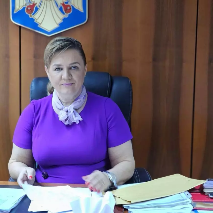O doamna imbracata cu o rochie mov sta la birou