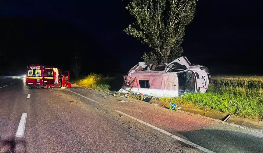 O mașină albă, răsturnată, duă ce a intart într-un pom pe drumul E85, pe șosea este și o ambulanță roșie