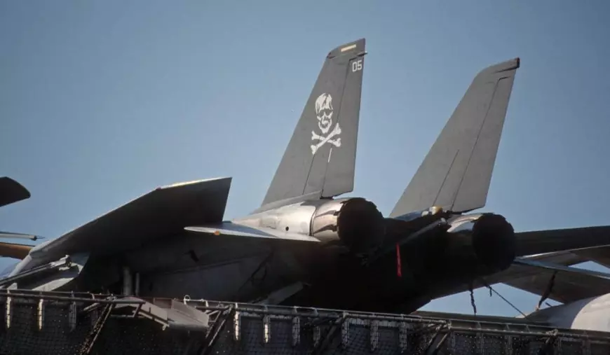 Aripa din spate a unui avion F-14 Tomcat este neagră și are desenat un cap de mort pe ea.