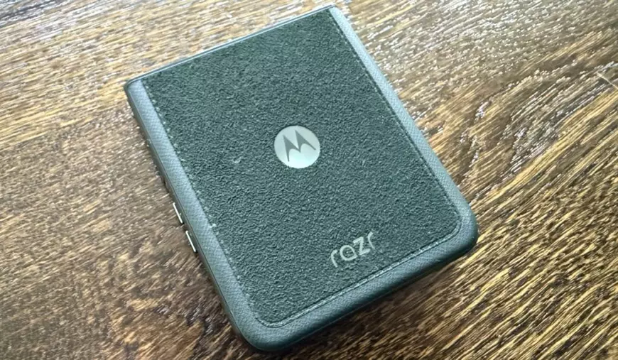 Un telefon Motorola Razr 60 Ultra verde, așezat pe un fundal de lemn.