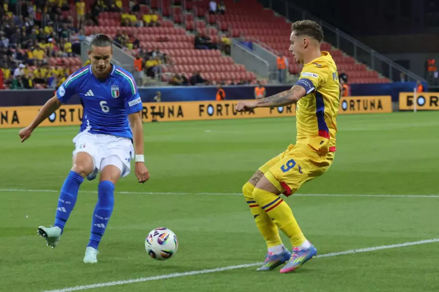 un jucator italian in albastru si un jucator roman in galbenin duel pe teren