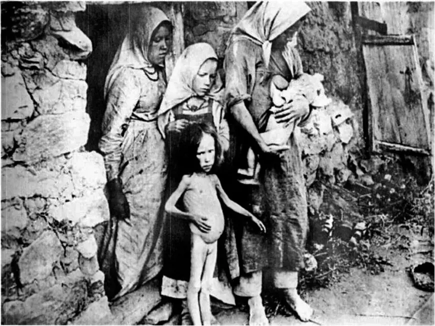 holodomurul ucrainean. in aceasta imagine de epoca s eobserva mai multe femeisi copii subnutriti, slabi, cu burtile umflate, aflati in pragul mortii in urma masurilor luate de Stalin