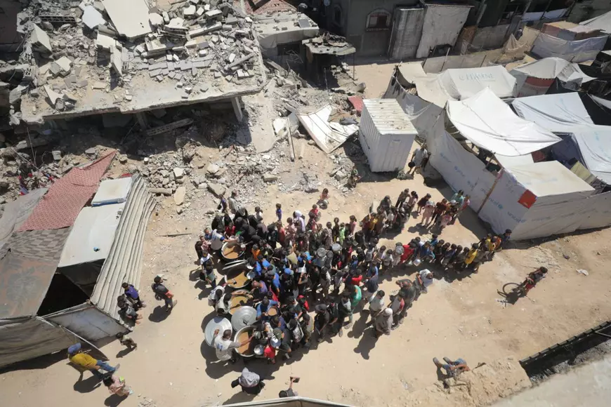 Palestinieni care așteaptă să primească ajutoare umanitare, în Gaza.