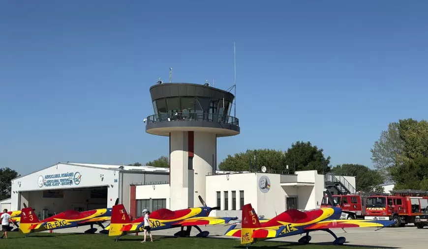 Trei avioane Extra colantate în tricolorul României, pe iarbă, în fața hangarului de la Aerodromul Clinceni.