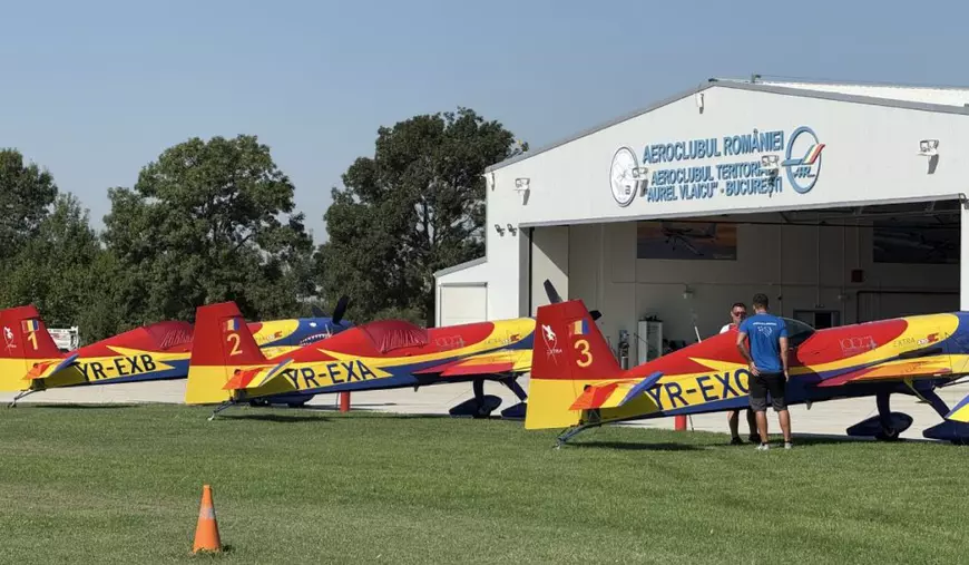 Trei avioane Extra colantate în tricolorul României, pe iarbă, în fața hangarului de la Aerodromul Clinceni.