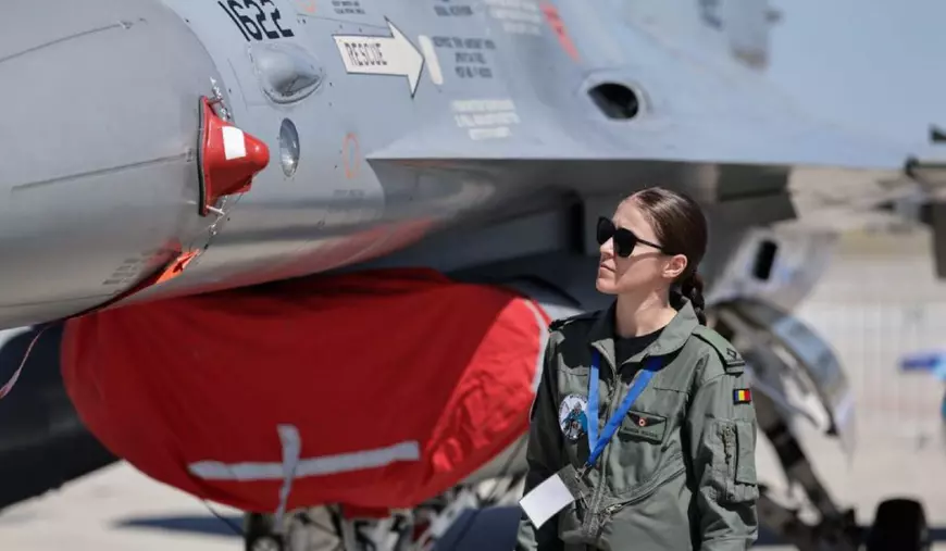 Bianca Botaș, în combinezon, în fața avionului său F-16 Fighting Falcon.