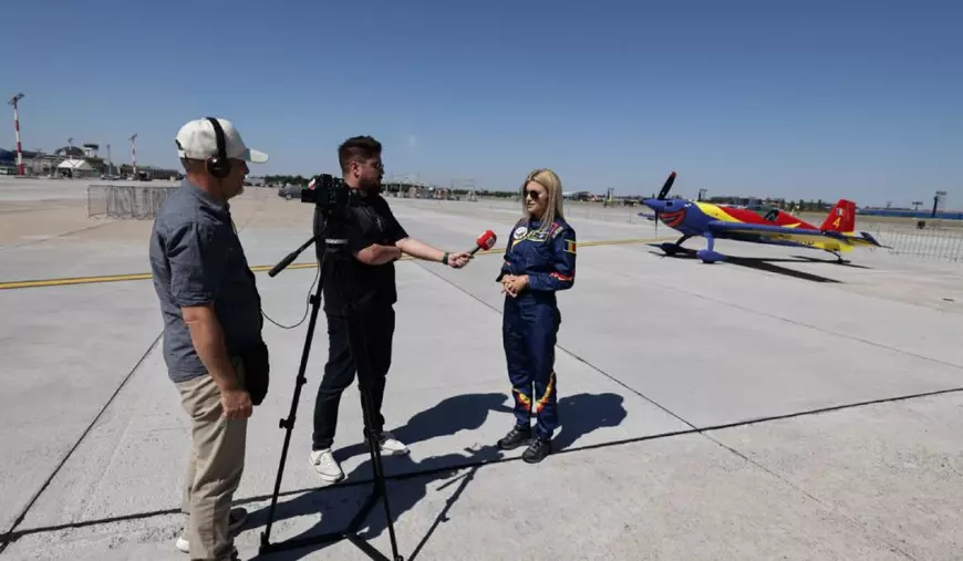 Andreea Bănesaru, oferind un interviu ziarului Libertatea, cu avionul său Extra 330SC în fundal, pe Aeroportul Băneasa în cadrul BIAS 2025.