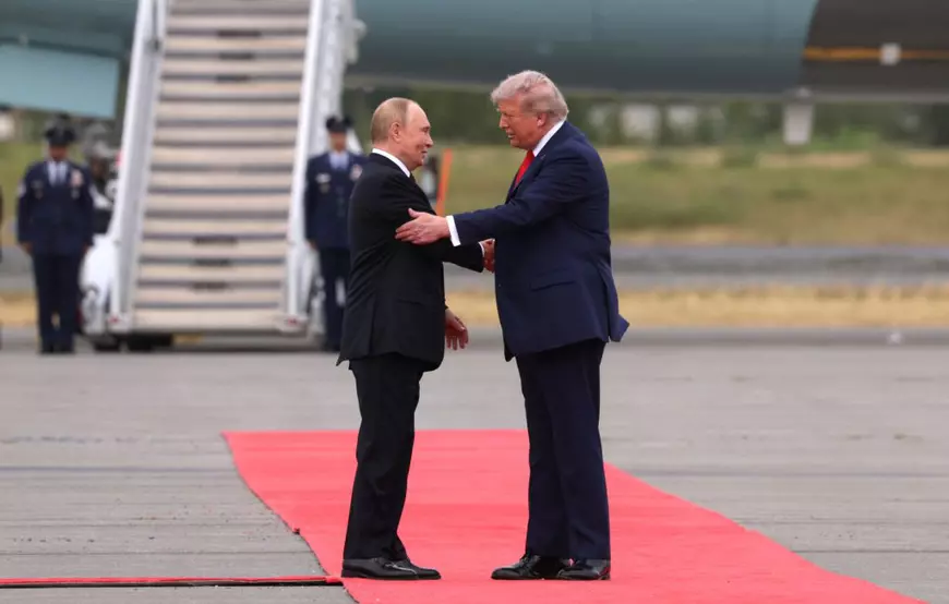 Vladimir Putin (stânga) și Donald Trump (dreapta) surprinși pe covorul roșu, vineri - 15 august 2025. Liderul american are o mână pusă pe umărul lui Putin