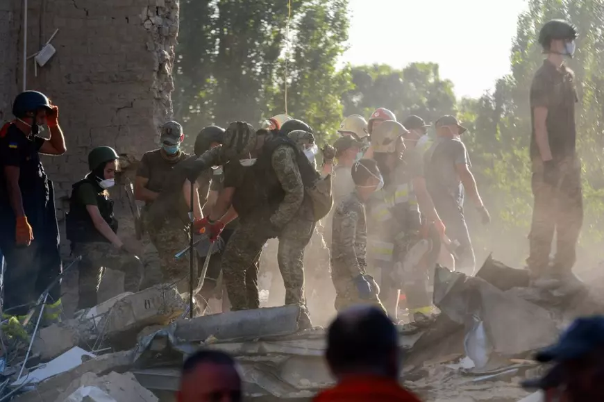 Echipele de salvare lucrează la locul unui bloc de apartamente avariat în urma atacurilor cu rachete rusești, în contextul atacului Rusiei asupra Ucrainei, la Kiev