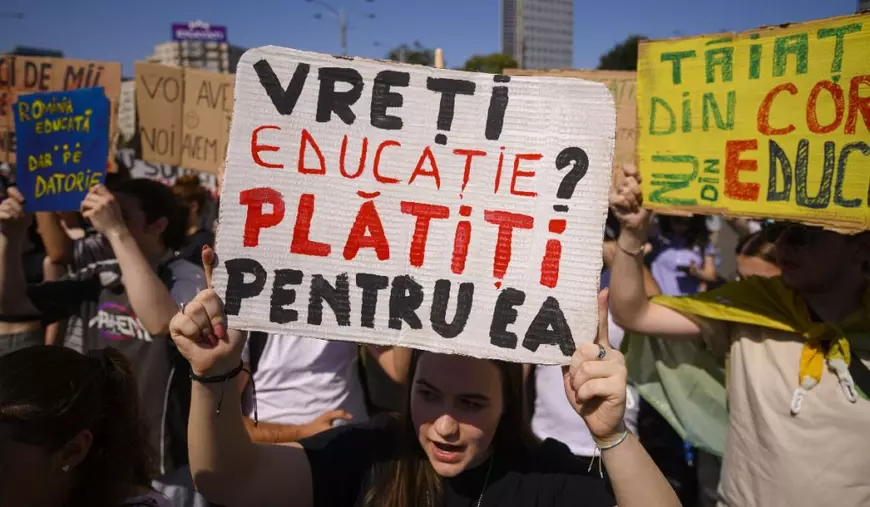 Tineri afiseaza pancarte in timpul unui protest organizat de Alianta Nationala a Organizatiilor Studentesti din Romania (ANOSR) impotriva reducerii fondurilor pentru burse, in fata Guvernului, in Piata Victoriei din Bucuresti, joi, 26 iunie 2025