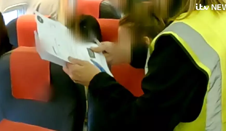 Imagini din avionul in care sunt deportati infractori români din Marea Britanie. Se văd scaunele și vestele galben fosforescent ale polițiștilor