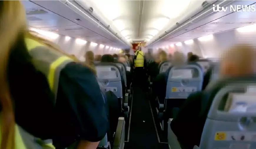 Imagini din avionul in care sunt deportati infractori români din Marea Britanie. Se văd scaunele și vestele galben fosforescent ale polițiștilor