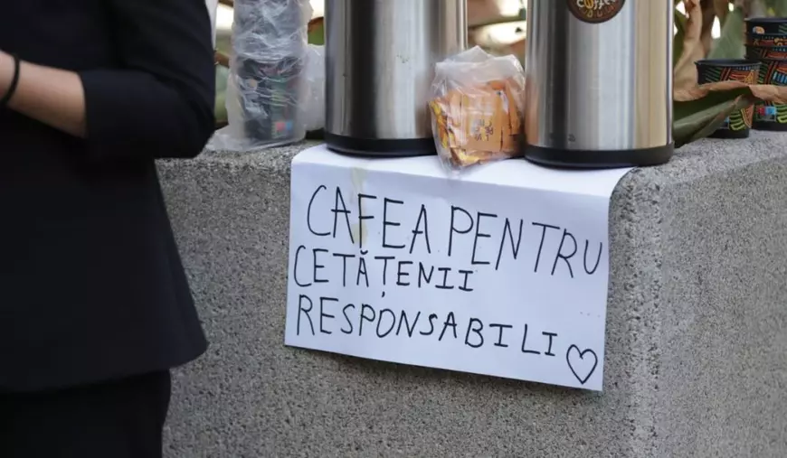Un semn pe o coala ce hârtie unde scrie cu majuscule „Cafea pentru cetățenii responsabili”. Coala de hârtie este pătată de cafea și este așezată sub două fierbătoare cu cafea, București, 28 septembrie 2025