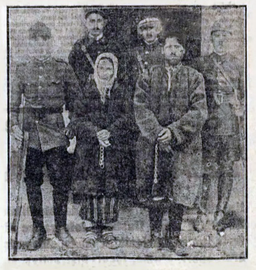 O totografie alb negru dintr-un ziar cu o femeie si sotul ei inconjurati de jandarmi