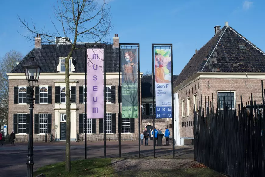 Exteriorul Muzeul Drents din Assen, unde erau expuse artefactele dacice, surprins într-o zi senină, cu bannerele expoziției la intrare. Imaginea oferă un cadru sobru și calm, în contrast cu jaful spectaculos care a avut loc aici în urmă cu un an.