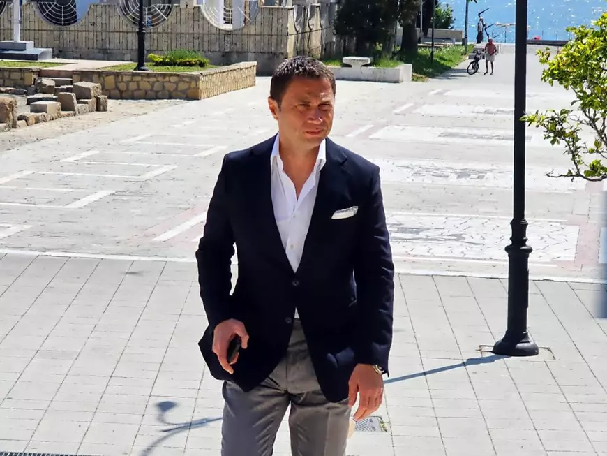 Radu Cristian, primarul municipiului Mangalia, imbracat in pantaloni crem si sacou negru, pe faleza