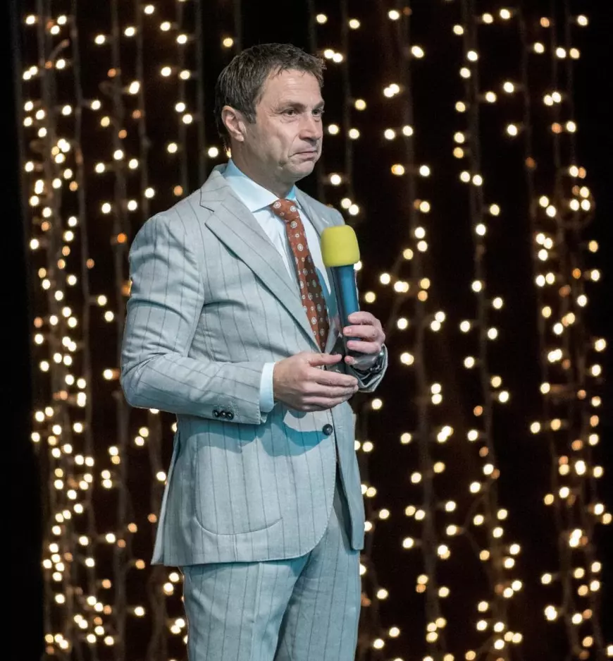 Radu Cristian, primarul municipiului Mangalia, in costum gri cu dungi, vorbeste la microfon pe o scena