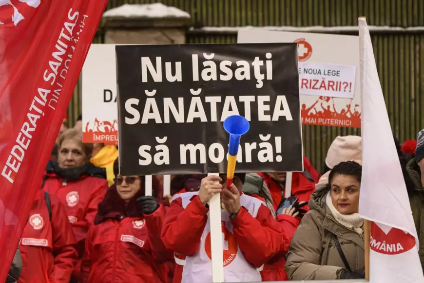 Un barbat afiseaza o pancarta pe care scrie: 