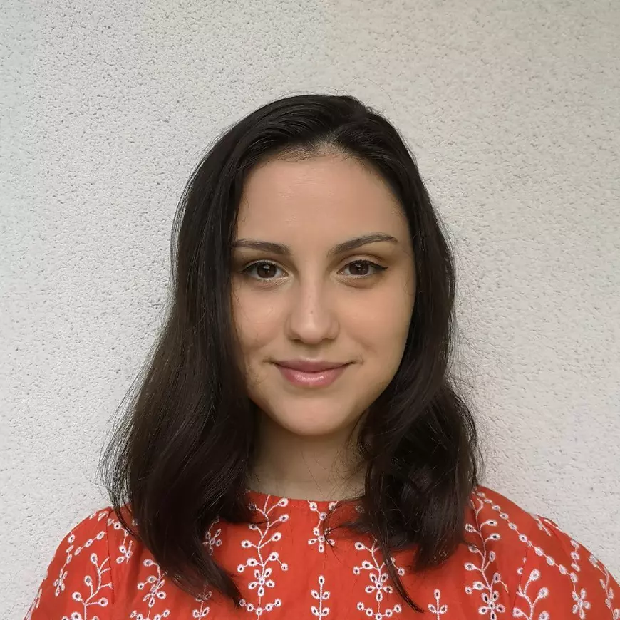 O femeie îmbrăcată într-o bluză rosie. cu flori albe