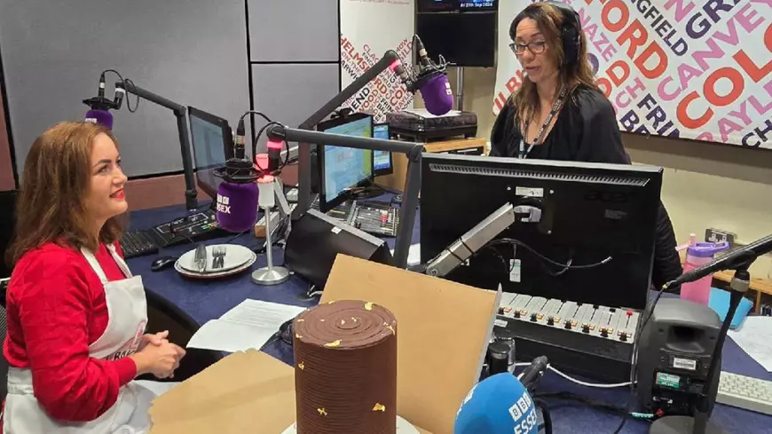 O femeie in bluză roșie, într-un studio, alături de prezentatoare, cu un tort de ciocolată de 16 etaje