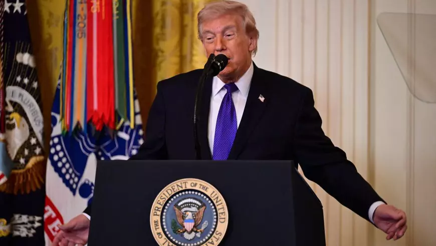 Președintele SUA, Donald Trump, vorbește în timpul ceremoniei de decernare a Medalia de Onoare în Sala de Est a Casei Albe din Washington, Statele Unite ale Americii. Imbracat la costum negru, camsa alba si cravata albastra, Trump gesticuleaza larg cu mainele deparatate de corp