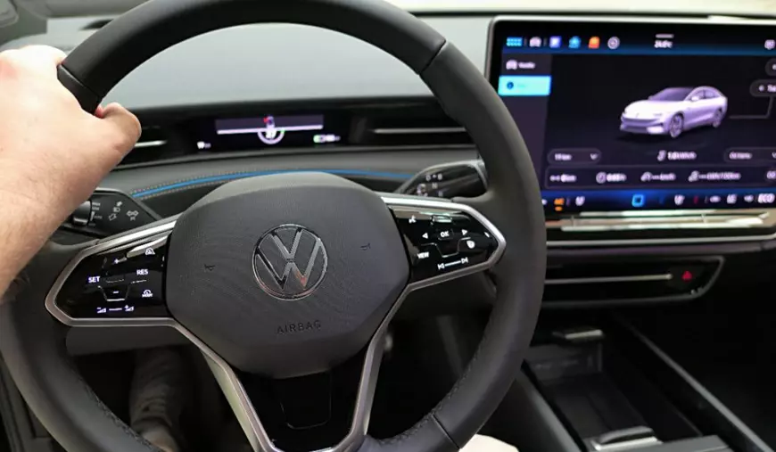 Un bărbat care conduce un Volkswagen nou cu ecran și comenzi tactile