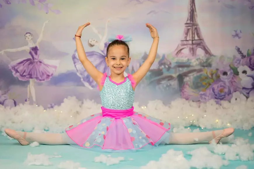 O fetita balerina intr-o rochita roz cu albastru