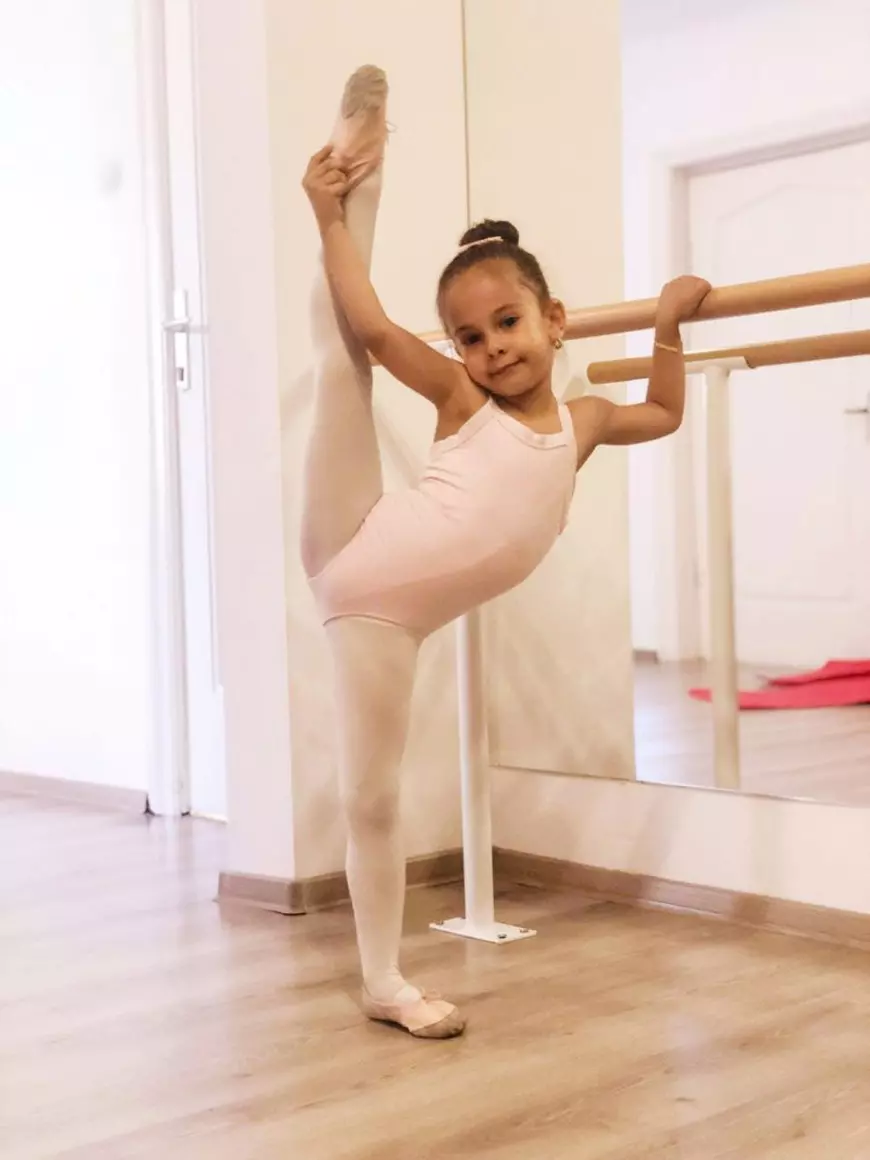 O fetita balerina face exercitii la bara