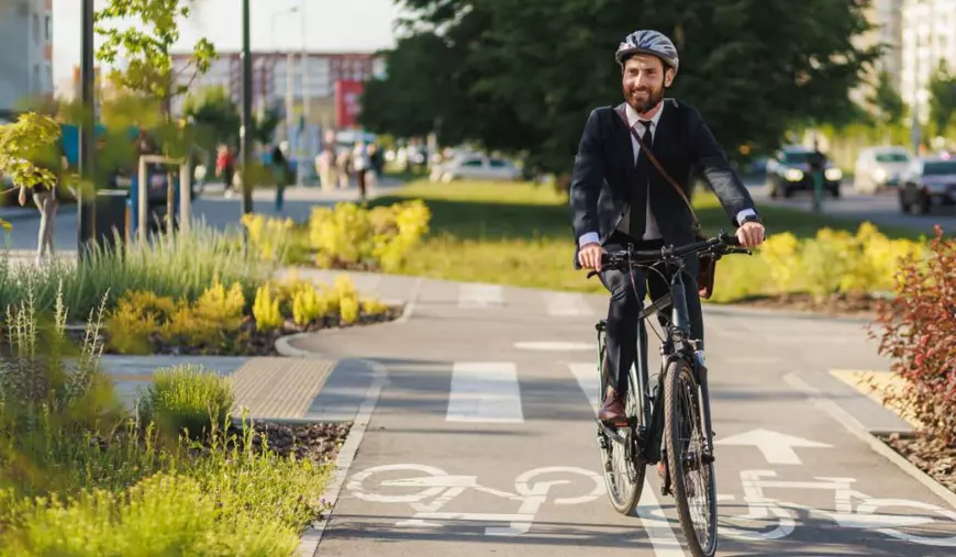Bărbat fericit, in costum, pe bicicleta, in oras