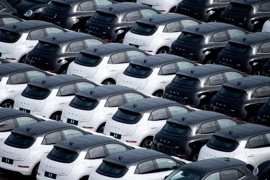 Mașini electrice chinezești albe și negre într-o parcare