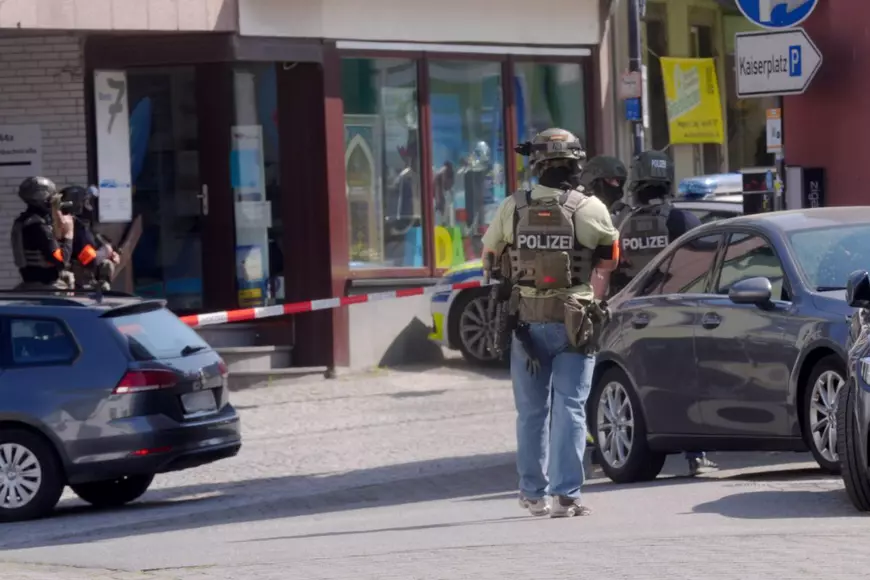 Luare de ostatici în Sinzig, Germania, un polițist stă în fața băncii în care se află ostaticii.