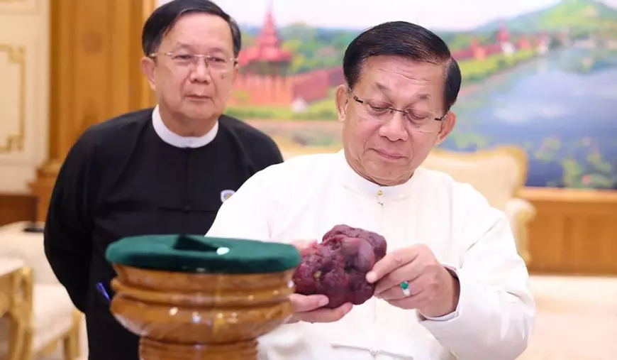 Această fotografie de presă, realizată și difuzată pe 7 mai 2026 de către Myanmar Radio and Television (MRTV), îl înfățișează pe Min Aung Hlaing (dreapta), liderul loviturii de stat din Myanmar devenit președinte, ținând în mână un rubin de 11.000 de carate în Naypyidaw, după ce acesta a fost descoperit într-o zonă minieră din Mogok, în regiunea Mandalay