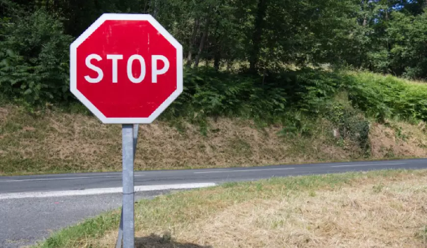 Indicatorul rutier STOP afișat pe partea dreaptă, la intersecția cu un alt drum