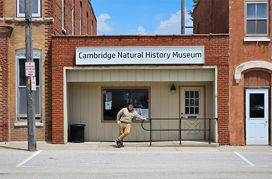 Un baiat pozeaza in fata muzului de Istorie Naturala din Cambridge, SUA