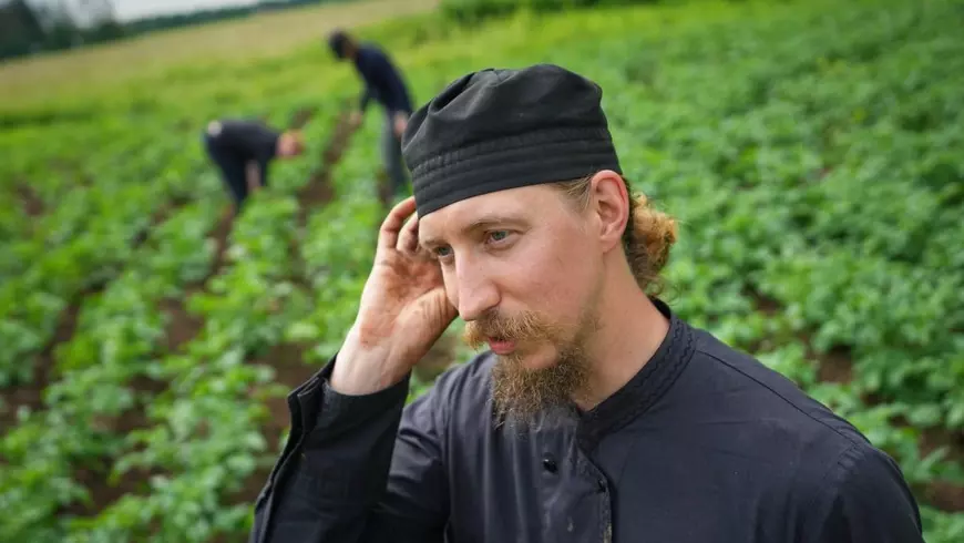 Călugărul Paisios lucrează în grădina mănăstirii împreună cu tineri voluntari Foto: Profimedia