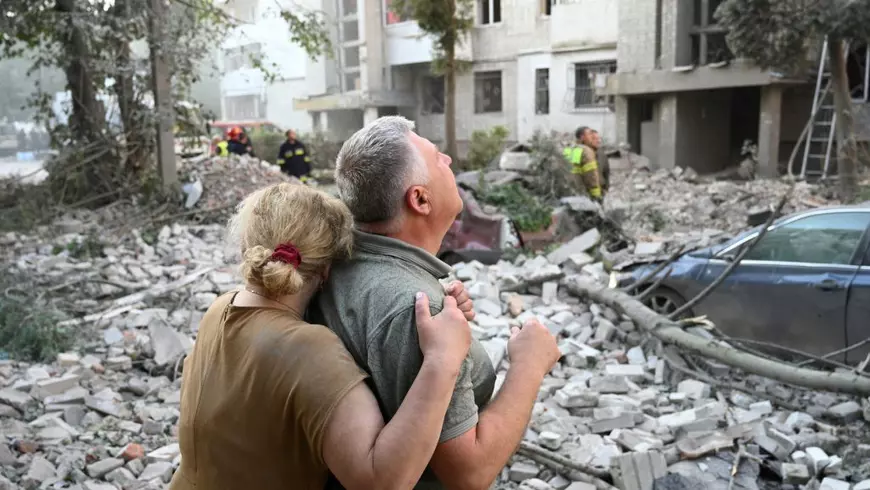 Un bărbat din Liov, consolat de soția sa, se uită la fostul lui apartament, care a fost distrus de rușii ce pretind că atacă „instalații militare” Foto: Profimedia
